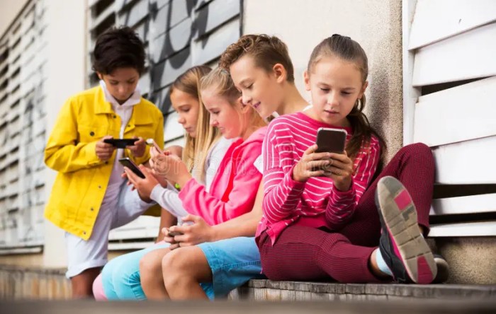 Two positive kids playing with smartphones in domestic interior Stock ... Why do kids love playing with smartphones
